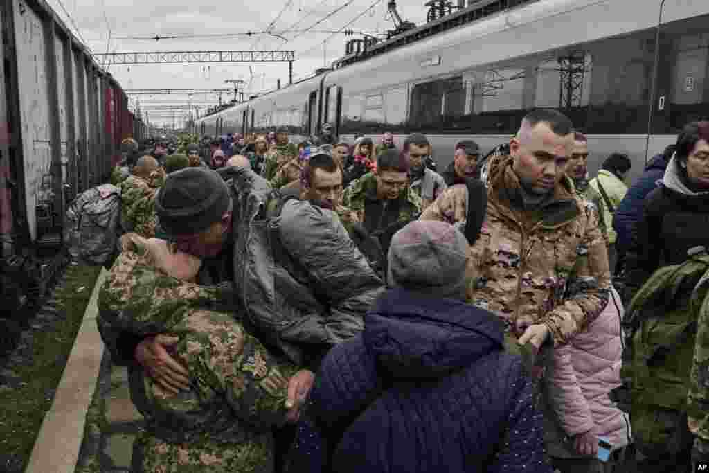 A Ukrainian woman soldier, left, kisses her husband as they meet at a railway station close to the frontline in Kramatorsk, Donetsk region.