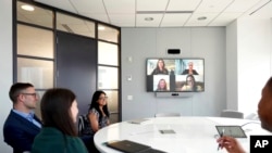 Workers in the office collaborate with virtual peers at American Express, where colleagues can work in the office, at home, or adopt a hybrid schedule, March 16, 2022, in New York. (American Express via AP Images)