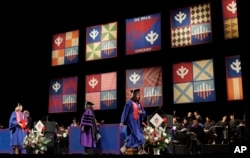 FILE - Students receive diplomas during graduation ceremonies on June 13, 2009, at DePaul University. (AP Photo/M. Spencer Green)