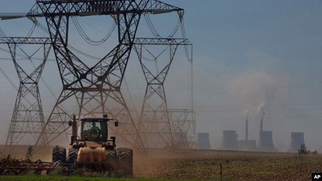 FILE - The land is plowed under electrical pylons leading from a coal-powered electricity-generating plant east of Johannesburg, South Africa, on Nov. 17, 2022.