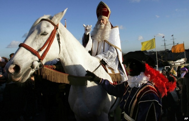 FILE - Sinterklaas, the Dutch equivalent of Santa Claus, arrives at the roof of the Nemo Museum in Amsterdam, Netherlands, Nov. 29, 2006. Dutch Protestants who settled in New York brought Sinterklaas in the 17th century to America. (AP Photo/ Evert Elzinga, File)