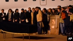 FILE - Relatives stand by the coffin of French journalist Frederic Leclerc-Imhoff of BFM TV news, who was killed in Ukraine, at Le Bourget Airport, north of Paris, June 9, 2022.