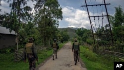 FILE - Indian army soldiers patrol a deserted village in Churachandpur, in the northeastern Indian state of Manipur, June 20, 2023.