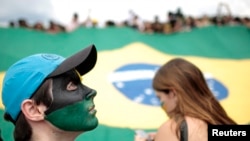 ARCHIVO - Las personas que ostentan la bandera de Brasil protestan durante la "marcha contra la corrupción" en Brasilia el 12 de octubre de 2011.