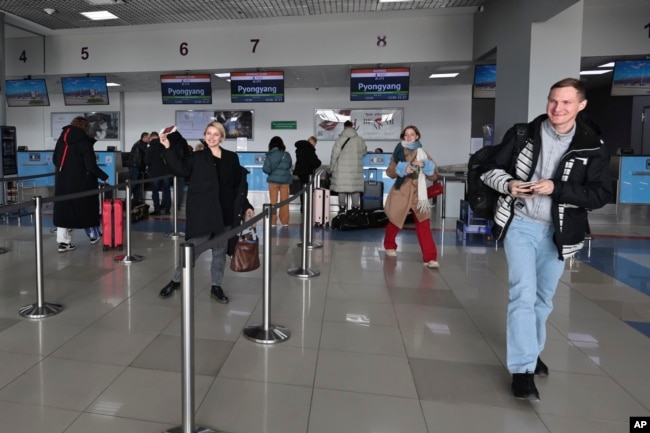 Members of the first group of Russian tourists walk after checking-in to board a plane to fly to North Korea at the international airport outside in Vladivostok, Russia's Far East region of Primorsky Krai, Feb. 9, 2024.