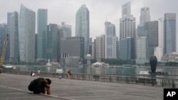 FILE - A man takes a nap as the central business district is shrouded by haze in Singapore, on Sept. 23, 2019. 