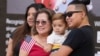 Rita Guevara of the Philippines, center, takes a photo with her family following a naturalization ceremony, Sept. 15, 2023, in Miami. 