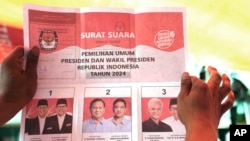 Seorang petugas memegang surat suara yang menunjukkan suara capres Prabowo Subianto dan pasangannya Gibran Rakabuming Raka, putra sulung Presiden Indonesia Joko Widodo, saat penghitungan suara di TPS setelah pemilu di Jakarta, Rabu, 14 Februari 2024. (AP/Tatan Syuflana)