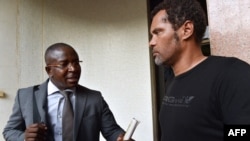 FILE—Guy Herve Kam, lawyer of the ''Balai Citoyen'' movement speaks with spokesperson of the group, Serge Martin Bambara Smockey (R), in Burkina Faso, on November 12, 2014 in Ouagadougou. 