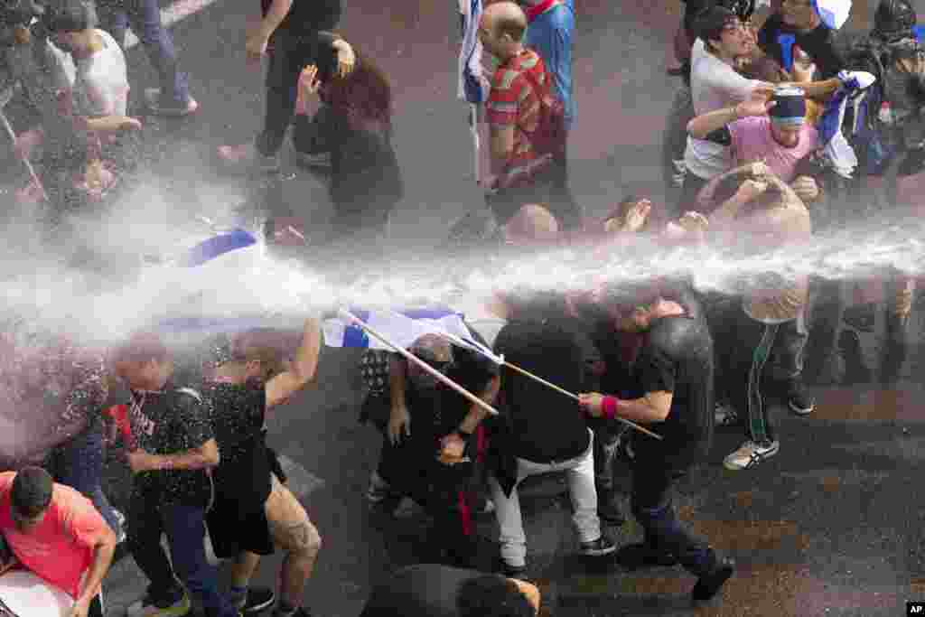 Police use a water cannon to disperse Israelis blocking the freeway during a protest against plans by Prime Minister Benjamin Netanyahu&#39;s government to overhaul the judicial system in Tel Aviv.