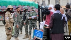 Pakistan's border police check the papers of Afghan people before they cross into Pakistan at the zero point Torkham border crossing between Afghanistan and Pakistan, in Nangarhar province, Feb. 25, 2023.