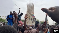 Apoiantes das forças de defesa e segurança nigerinas reúnem-se durante uma manifestação diante da assembleia nacional em Niamey, a 27 de julho de 2023