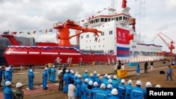 资料照片: 2018年9月10日，人们在中国上海的一家造船厂参加中国第一艘国产极地破冰船“雪龙2号”的下水仪式。（路透社照片）