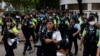 FILE - Police stand guard outside the West Kowloon Magistrates' Courts building during the verdict of the 47 pro-democracy activists charged under the national security law, in Hong Kong, China, May 30, 2024