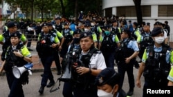 FILE - Police stand guard outside the West Kowloon Magistrates' Courts building during the verdict of the 47 pro-democracy activists charged under the national security law, in Hong Kong, China, May 30, 2024