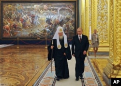 FILE - Russian President Vladimir Putin and Russian Orthodox Patriarch Kirill arrive to attend the gala reception marking the National Unity Day at the Kremlin in Moscow, Russia, Nov. 4, 2014.