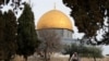 A Palestinian woman reads the holy book of Koran in the compound known to Muslims as the Noble Sanctuary and to Jews as the Temple Mount, in front of the Dome of the Rock, during the first day of Ramadan in Jerusalem's Old City, March 23, 2023. 