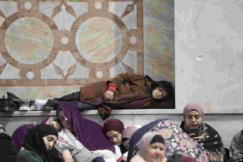 Palestinians rest before Friday prayers at the Dome of the Rock Mosque in the Al-Aqsa Mosque compound in the Old City of Jerusalem during the Muslim holy month of Ramadan.