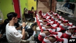 A staff of a small shoe manufacturer makes their new products as they make an introductory video to be posted on social media in Bogor, West Java, Sept. 27, 2023.