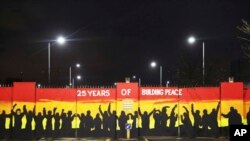 Sebuah mural di gerbang perdamaian Lanark Way di Belfast, Irlandia Utara untuk memperingati 25 tahun Perjanjian Jumat Agung yang mengakhiri konflik di Irlandia Utara, Rabu, 5 April 2023. (Foto: Peter Morrison/AP Photo)