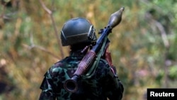 រូបឯកសារ៖ ទាហានម្នាក់នៃក្រុម Karen National Liberation Army ស្ពាយគ្រាប់កាំភ្លើងផ្លោង RPG នៅមូលដ្ឋានទ័ពមួយនៅមីយ៉ាន់ម៉ានៅខាងក្រៅទីក្រុង Myawaddy ជាប់ព្រំដែនជាមួយប្រទេសថៃ កាលពីថ្ងៃទី១៥ ខែមេសា ឆ្នាំ២០២៤។ (Reuters)