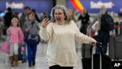 Putnica razgovara telefonom na aerodromu u Nešvilu u Tenesiju (Foto: AP/George Walker IV)