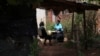 Siridzayi Dzukwa, right, talks to Tambudzai Tembo outside her house near Harare, Zimbabwe, May 15, 2024. In Zimbabwe, talk therapy involving park benches and a network of grandmothers has become a saving grace for people with mental health issues.