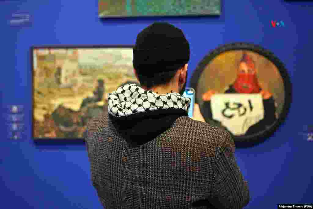 Un joven palestino observa dos de las obras que forman parte de la muestra "Esto no es una exposición".