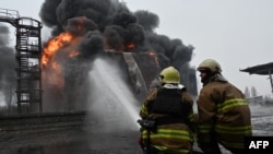 Ukrainian emergency personnel douse water to extinguish flames after a fire erupted at the site of a drone attack in Kharkiv, Feb. 10, 2024. Seven people, including three children, were killed in a Russian drone attack on the city of Kharkiv. 