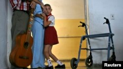 Una niña con necesidades especiales abraza a un maestro en la escuela Solidaridad con Panamá, en la Habana, el 15 de mayo de 2008. 