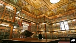 FILE - A 1455 Biblia Latina by Johannes Gutenberg and Johann Fust, foreground left, is on display inside the personal library of Pierpont Morgan, at the Morgan Library and Museum, in New York, April 25, 2006. Three times per year, a library curator turns the page.