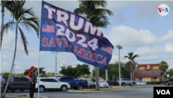 Una bandera de grandes dimensiones es sostenida por un manifestante pro Trump en Palm Beach, Florida, el 3 de abril de 2023. [Foto: Luis Felipe Rojas, VOA]