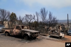 Burnt cars and houses after yesterday's fire in Mandra, west of Athens, on Wednesday, July 19, 2023. Fast-moving wildfires swept across hills in the searing heat outside the Greek capital on Tuesday, forcing authorities to close highways to help protect an oil refinery.