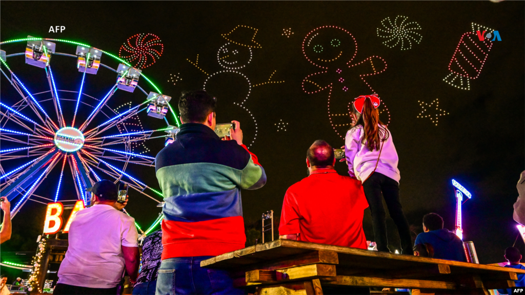 Desde Estados Unidos: Visitantes observan un espectáculo de drones formando figuras navideñas durante la feria Christmas Wonderland en Tropical Park en la ciudad de Miami, Florida, el 22 de diciembre de 2023.