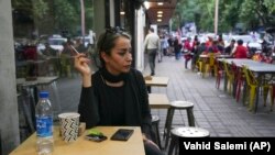 Seorang perempuan tampak duduk di sebuah cafe tanpa menggunakan hijab di Teheran, Iran, pada 29 April 2023. (Foto: AP/Vahid Salemi)