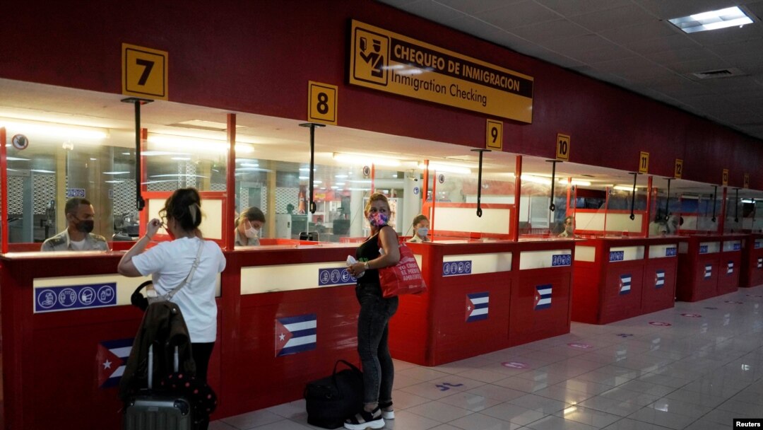 ARCHIVO - Turistas revisan sus pasaportes en el Aeropuerto Internacional José Martí en medio de preocupaciones sobre la propagación de la enfermedad del coronavirus (COVID-19), en La Habana, Cuba, el 15 de noviembre de 2020. 