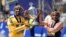 Sisay Lemma, of Ethiopia, left, winner of the men's division of the Boston Marathon, and Hellen Obiri, of Kenya, winner of the women's division of the race, hold the trophy on the finish line of the Boston Marathon in Boston, April 15, 2024.
