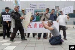 Protesters against former Taiwanese President Ma Ying-jeou (right) and Chinese President Xi Jinping (second from left) perform outside Taoyuan International Airport in Taoyuan City, Taiwan, April 1, 2024, as Ma Ying-jeou departs for China.