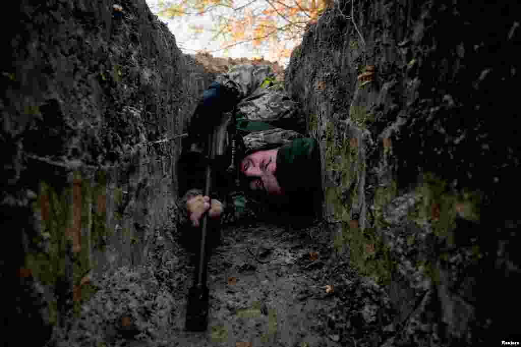 10 de marzo de 2022: Un soldado ucraniano busca cobijo durante un ataque aéreo, cerca de Demydiv.&nbsp;