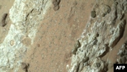 This handout image obtained on July 26, 2024, courtesy of NASA/JPL-Caltech/MSSS shows a reddish rock nicknamed "Cheyava Falls" in Mars' Jezero Crater on July 18, 2024, in an image captured by NASA's Perseverance rover. 