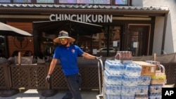 FILE - Driver Jose Viveros delivers beverages in the Little Tokyo district of Los Angeles on July 27, 2023. The U.S. Labor Department on Aug. 4, 2023, announced that 187,000 jobs were added last month.