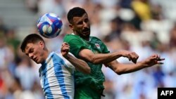 El mediocampista argentino #07 Kevin Zenon lucha por el balón con el delantero iraquí #18 Aymen Hussein en el partido de fútbol masculino del grupo B entre Argentina e Irak durante los Juegos Olímpicos de París 2024 en el estadio de Lyon, el 27 de julio de 2024.