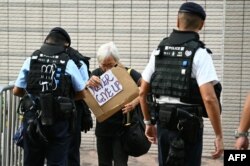 Aktivis pro-demokrasi yang dikenal sebagai Nenek Wong digeledah oleh polisi di luar pengadilan tempat persidangan keamanan nasional terbesar di Hong Kong terhadap 47 aktivis pro-demokrasi memulai argumen terakhirnya pada tanggal 29 November 2023. (Foto oleh Peter PARKS / AFP)