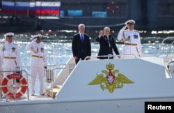 Presiden Rusia Vladimir Putin, Menteri Pertahanan Andrei Belousov dan Panglima Angkatan Laut Rusia Laksamana Alexander Moiseyev menghadiri parade tahunan Hari Angkatan Laut di Saint Petersburg, Rusia, 28 Juli 2024. (Sputnik/Anatoly Medved/Pool via REUTERS)