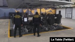 Agentes de la Policía Nacional Anticorrupción de Venezuela posan luego de notificar el allanamiento del restaurante ALTUM en Caracas en una operación presuntamente vinculada a la trama conocida como "Petro Cripto", reportó en Twitter la cuenta La Tabla.