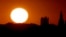 FILE - The sun sets beyond the downtown skyline of Kansas City, Mo., as the autumnal equinox marked the first day of fall, Sept. 22, 2013.