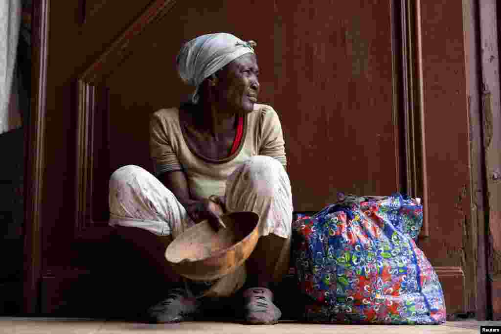 A woman begs for money at the entrance of the Our Lady of the Assumption Cathedral during Sunday Mass in Cap-Haitien, Haiti, April 28, 2024.