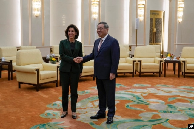 FILE - U.S. Commerce Secretary Gina Raimondo, left, shakes hands with Chinese Premier Li Qiang before their meeting at the Great Hall of the People in Beijing, Tuesday, Aug. 29, 2023. (AP Photo/Andy Wong, Pool)