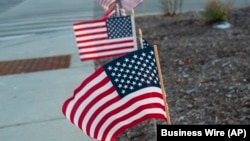 (FILE) American flags placed along a sidewalk