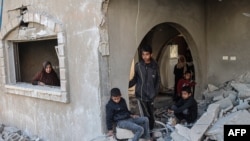 Palestinos revisan los escombros de la casa de la familia al-Faqawi que fue alcanzada en un ataque aéreo israelí durante la noche en Khan Yunis, en el sur de la Franja de Gaza, el 5 de marzo de 2024.
